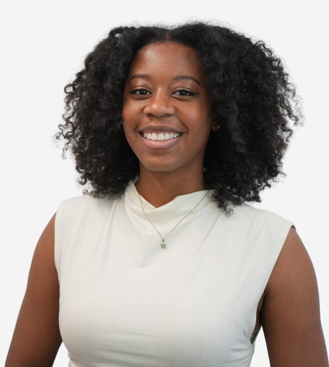 Smiling woman with curly black hair wearing a light sleeveless top against a white background.